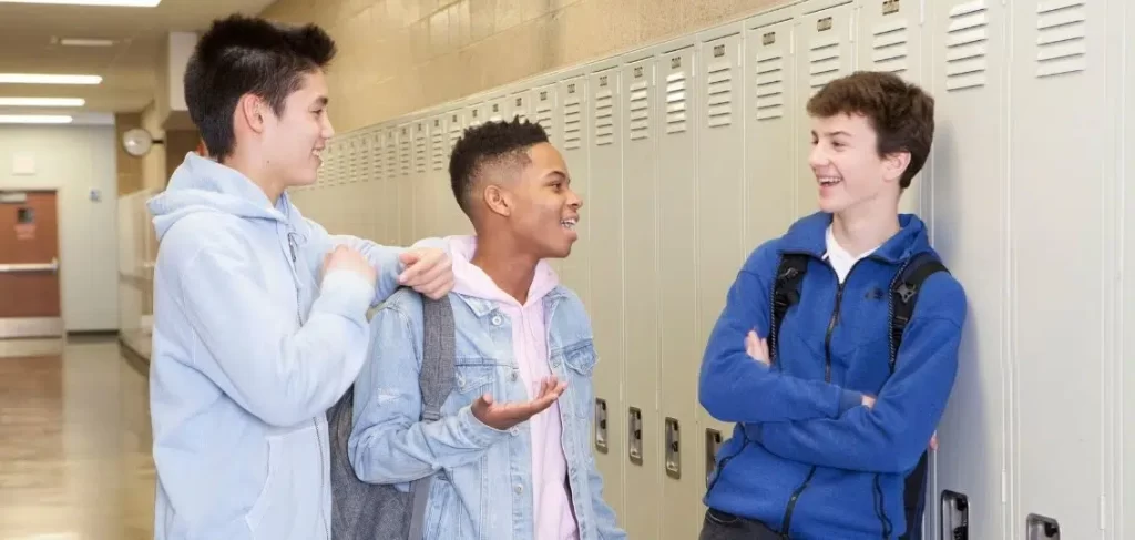 three teen boys talking to each other because they are friends